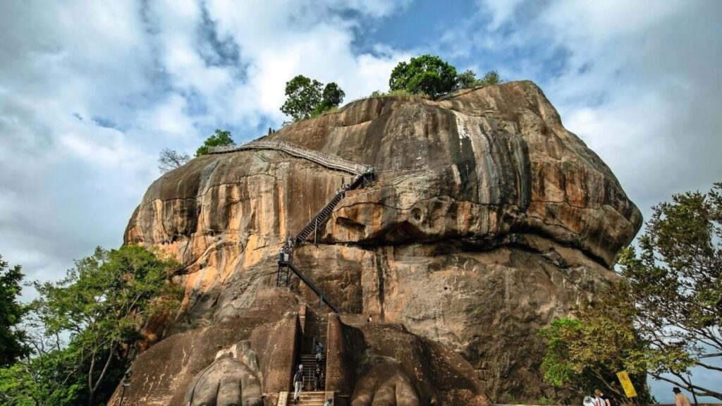 SİGİRİYA, SRİ LANKA - 15 Temmuz 2024: Turistler, Sri Lanka'daki Sigiriya Kaya Kalesi'ndeki Aslan Platformunda Aslan Pençeleri arasında yürüyor. Arka planda Sigiriya Kayası'nın zirvesine giden merdiven var